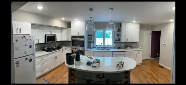 White kitchen remodel with curved island and pendant lighting